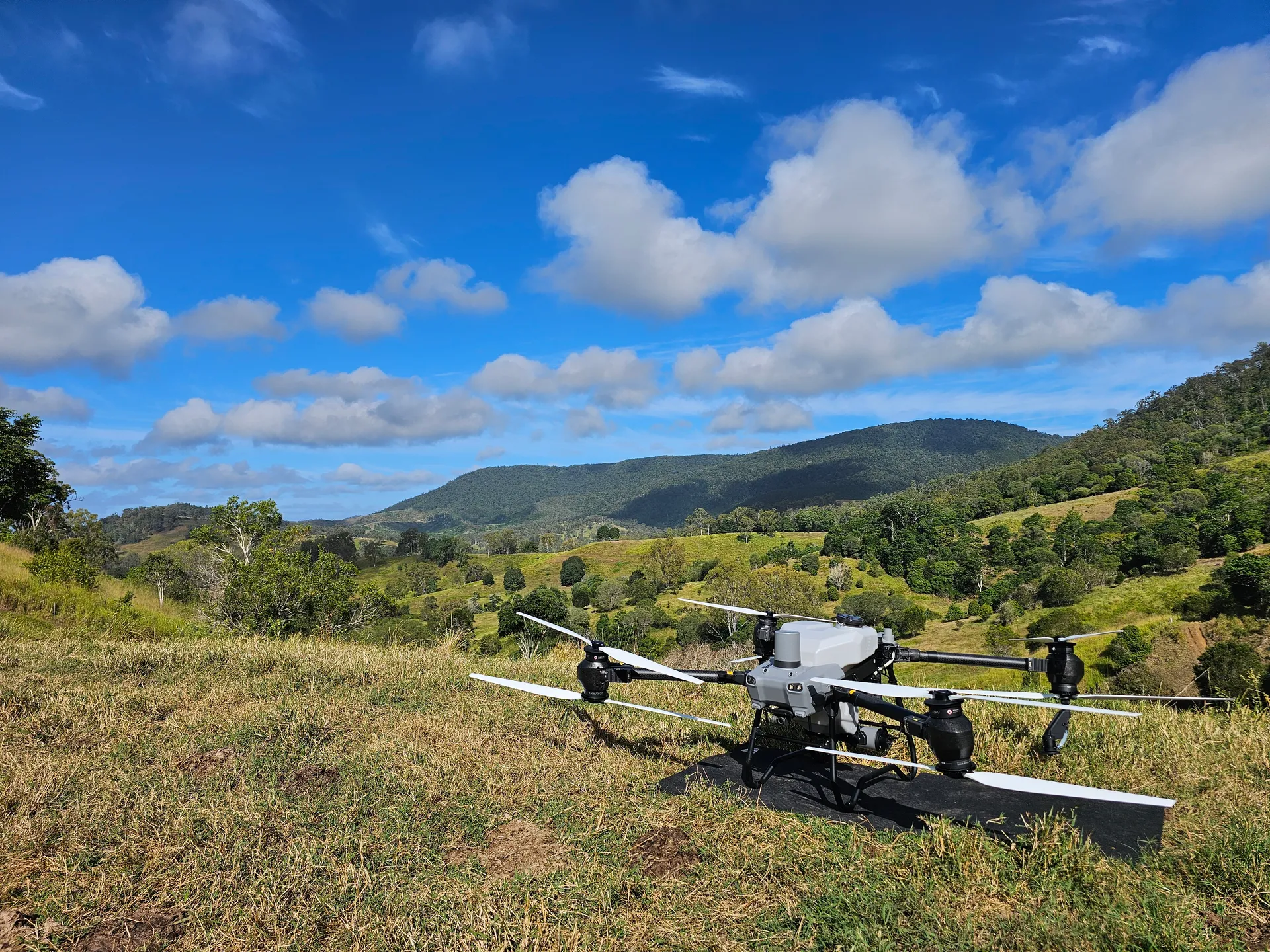 Spray drone on its landing pad overlooking a Sunshine Coast hinterland valley